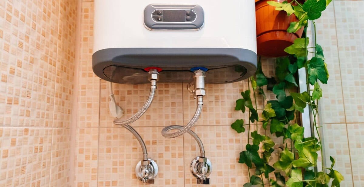 Compact wall-mounted hot water unit with inlet and outlet pipes
