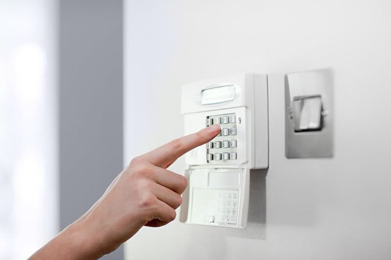 Hand operating a wall-mounted security keypad