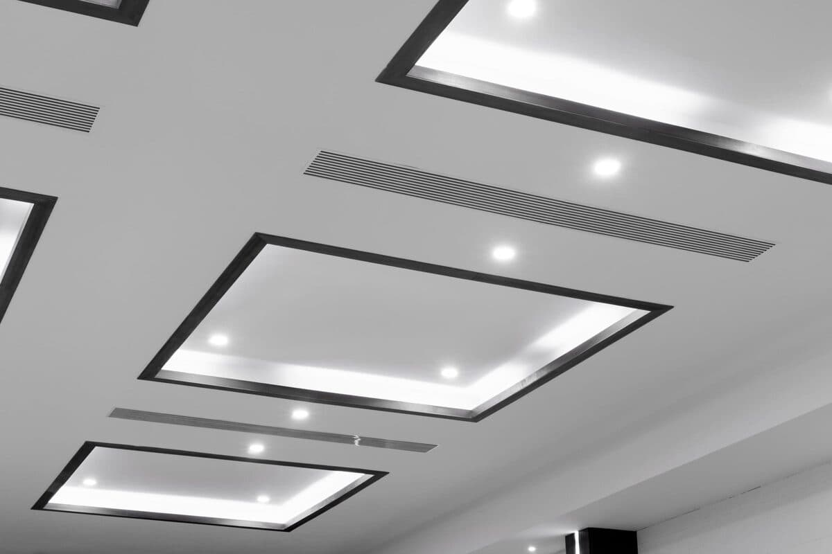 Licensed electrician installing modern LED ceiling lights as part of a Central Coast lighting upgrade