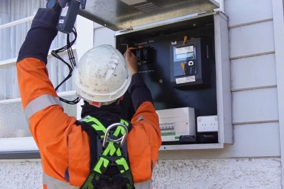 Worker using a clamp meter at an outdoor meter board